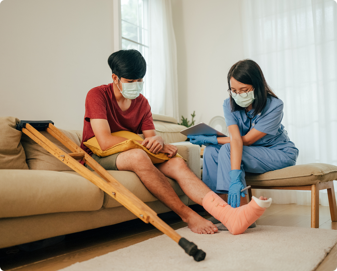 Nurse examining man's bandaged leg at home